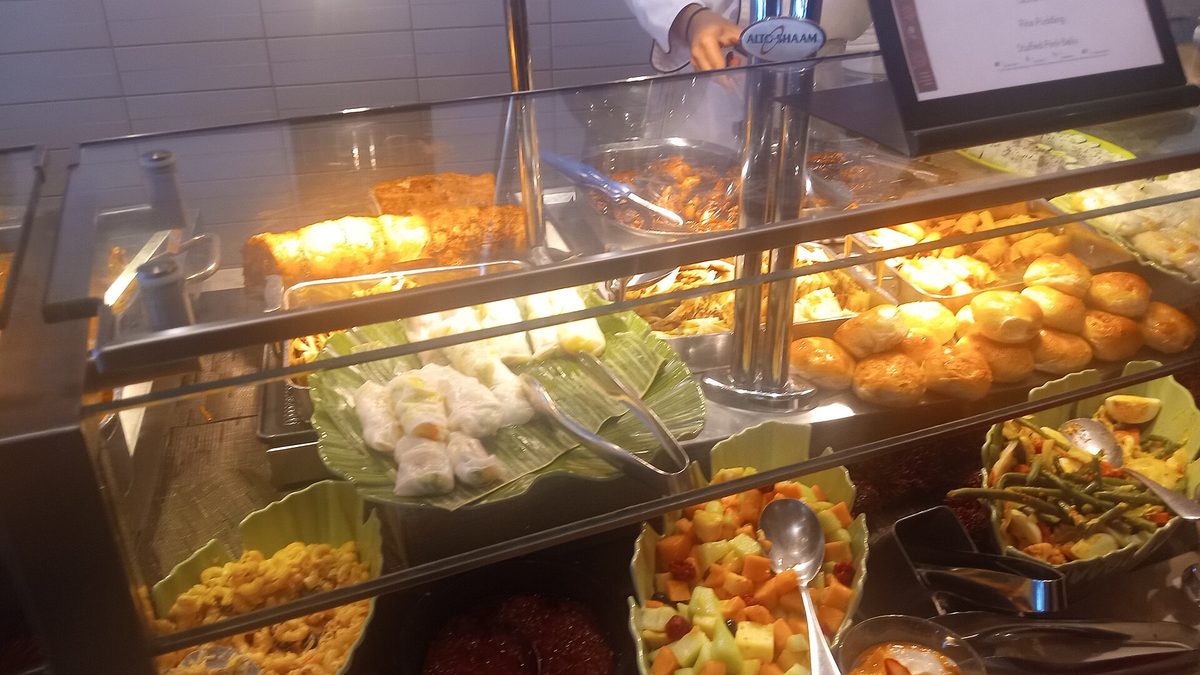 A long buffet counter lined with hot dishes, salads and desserts at a restaurant