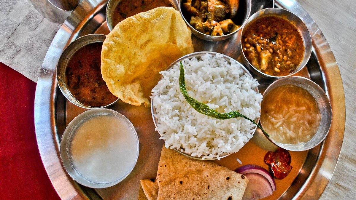 An Indian thali plate served with rice, dal, sabzi and side dishes