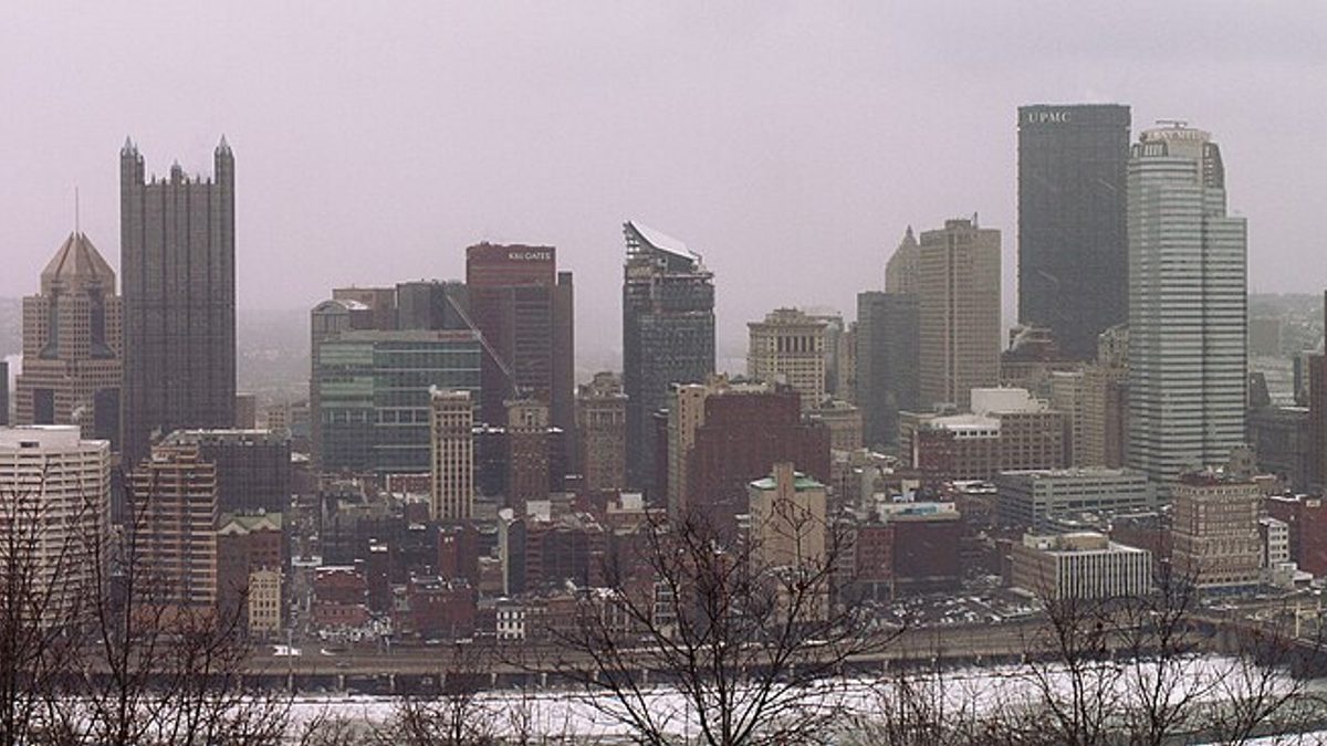 Downtown Pittsburgh skyline seen from Mount Washington in winter, with ice covering the banks of the Monongahela River