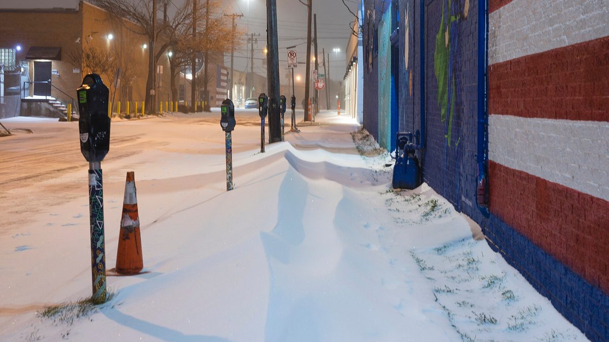 Snow drifted across a sidewalk and parking meters in the Deep Ellum district of Dallas during the February 2021 Texas winter storm